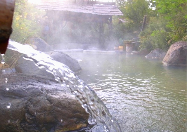 蓼科高原で宿をお探しの方は、天然の温泉を利用できる宿【尖石の湯】をぜひご利用ください。天然の温泉で作られた露天風呂の画像。